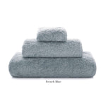 Three neatly folded towels from the Graccioza Egoist Bath Collection in small, medium, and large “French Blue,” crafted from Egyptian cotton, are stacked on a white background.
