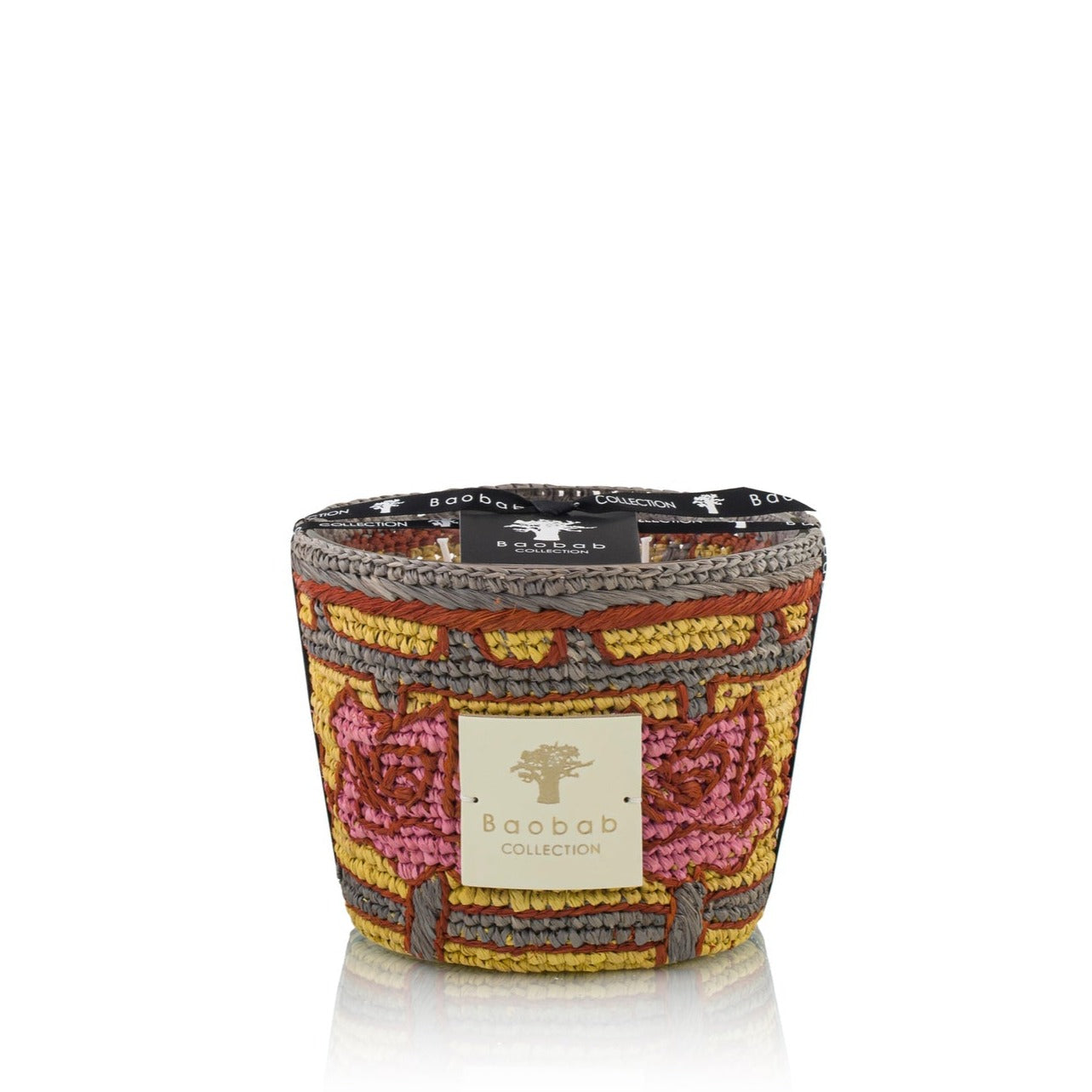 A colorful Baobab Collection Frida Draozy Magda scented candle with a decorative woven pattern on the exterior and a logo on the front, set against a white background.