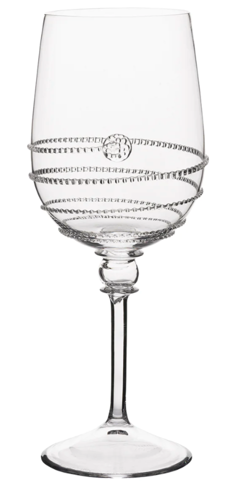 A clear wine glass from the Juliska Amalia Drinkware Collection features a decorative spiral pattern, a small circular motif on the bowl, and intricate details on its thin stem and round base.