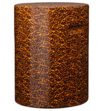 The Elton Stool by Made Goods is a cylindrical brown side table with a high-gloss, mottled faux tortoise shell pattern and an inset handle.