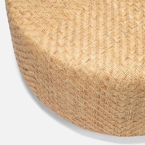 Close-up of the Moselle Coffee Table by Made Goods, featuring a round, woven rattan drum shape with a herringbone pattern on a neutral background.