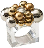The Bauble Napkin Ring by Kim Seybert features a clear lucite base accented with metallic gold and silver spheres—an elegant, jewelry-inspired touch for your table setting.