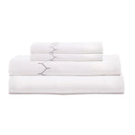 The Stitched Gray Sheet Set by John Robshaw, crafted from organic cotton with subtle hand embroidery, is neatly folded and displayed on a plain white background.