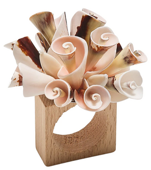The Kim Seybert Seashell Burst Napkin Ring features an arrangement of curled, shell-like pieces in beige and brown, adding a decorative touch perfect for seaside gatherings.