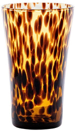 The Juliska Puro Tortoiseshell Drinkware Collection features a tall glass tumbler with a brown and amber tortoiseshell pattern, ideal for serving cocktails or mixing with other pieces from the collection.