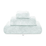 Three neatly stacked pale blue towels of different sizes from the Egoist Bath Collection by Graccioza, crafted from high density Egyptian cotton, displayed on a white background.