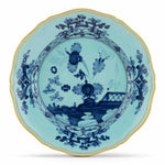Part of the Oriente Italiano Iris with Gold Dinnerware Collection by Ginori 1735, this round scalloped-edge plate showcases blue floral and landscape motifs on a light blue background accented with a slender yellow rim.