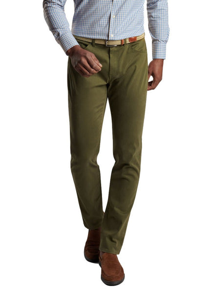 A man wearing Peter Millar Ultimate Sateen Five-Pocket Pant and a striped shirt.