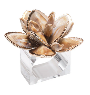The Kim Seybert Beachcomber Napkin Ring Set features polished seashell lotus flowers on clear bases, adding a charming coastal touch to any table setting.
