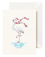 The Crane Festive Flamingo Card Set features greeting cards with a winter flamingo—wearing a Santa hat and red striped scarf, standing on one leg in water—with envelopes included.