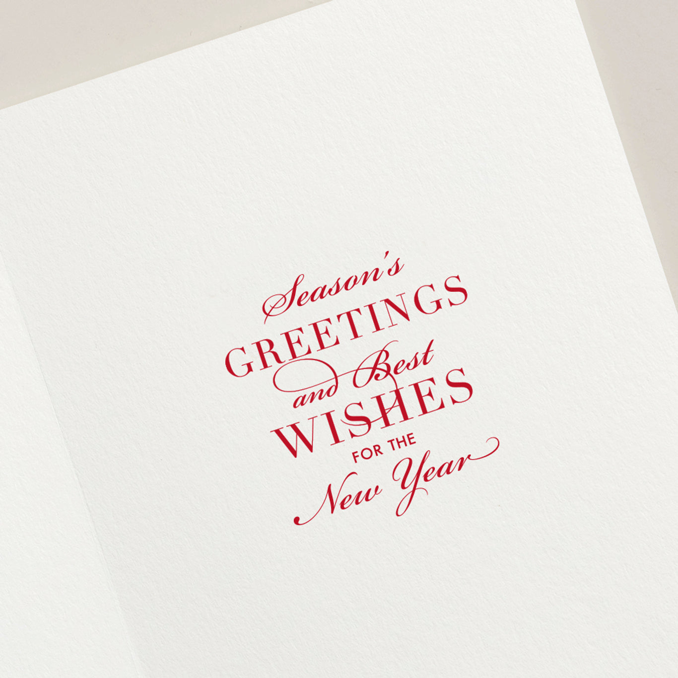 The Crane Snowflake Ornament Card Set features white holiday cards with red cursive and serif text, "Season’s greetings and best wishes for the New Year," accented by a delicate silver snowflake ornament for festive charm.