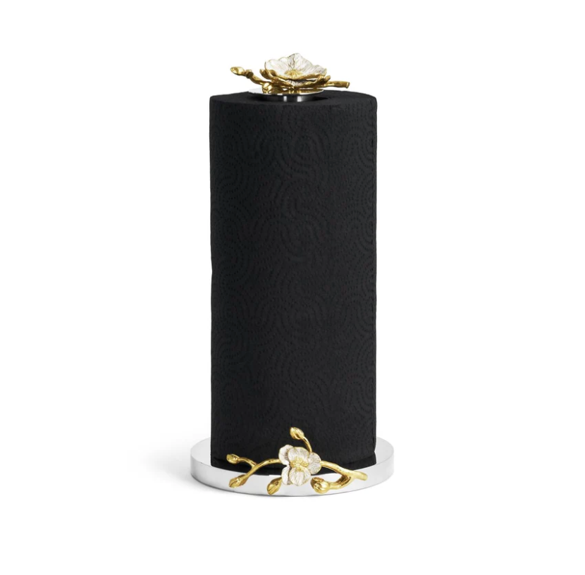 The Orchid Paper Towel Holder by Michael Aram features a black paper towel roll standing vertically on a silver holder, accented with gold and white floral designs at the base and top, capturing the elegance of the Orchid Collection.