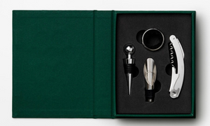 The Essentials Wine Tools by PrintWorks is a boxed set featuring a stopper, pourer, drip ring, and corkscrew in black foam inside a stylish green case—perfect for gifting.