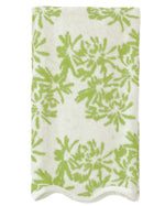 A folded white towel with a green floral design and scallop trim from the Weezie Towels x Meg Braff Bath Collection evokes a Palm Beach summer.