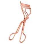 The Tweezerman Classic Eyelash Curler in metallic rose gold with a white silicone pad is shown on a white background—perfect for creating natural-looking curls and easy to slip into your makeup bag.