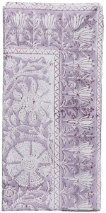 A folded fabric napkin from the Kim Seybert Provence Napkin Set features a detailed lavender and white floral and geometric block print, ideal for mixing with a matching tablecloth or other Provence Napkins for a cohesive, playful table setting.