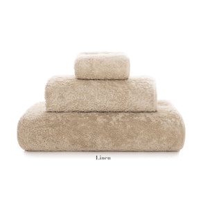 Three beige towels from the Egoist Bath Collection by Graccioza, in various sizes and made from high-density textile, are stacked in a pyramid shape on a white background.