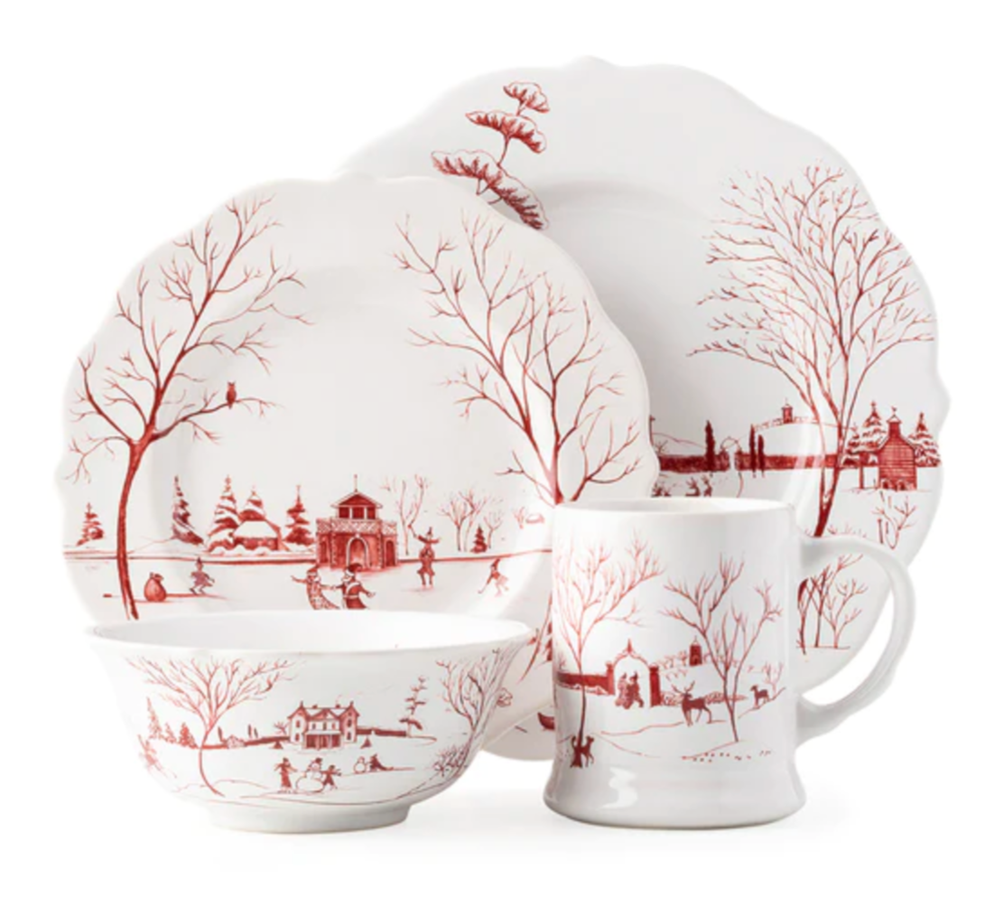 The Juliska Country Estate Winter Frolic Ruby Dinnerware Collection features white ceramic pieces with festive ruby scenes. This set includes two plates, a bowl, and a mug—perfect for adding charm to your seasonal gatherings.