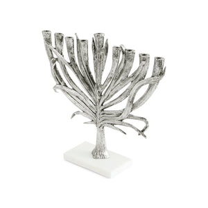 The Silver Palm Menorah, Small by Michael Aram features nine candle holders on a white rectangular base, inspired by the elegant Palm Collection and designed with silver tree branch accents.