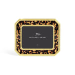 A rectangular picture frame from Michael Aram's Tortoise Frame Collection features a tortoiseshell pattern with gold trim and displays a card marked "Michael Aram" at the center.