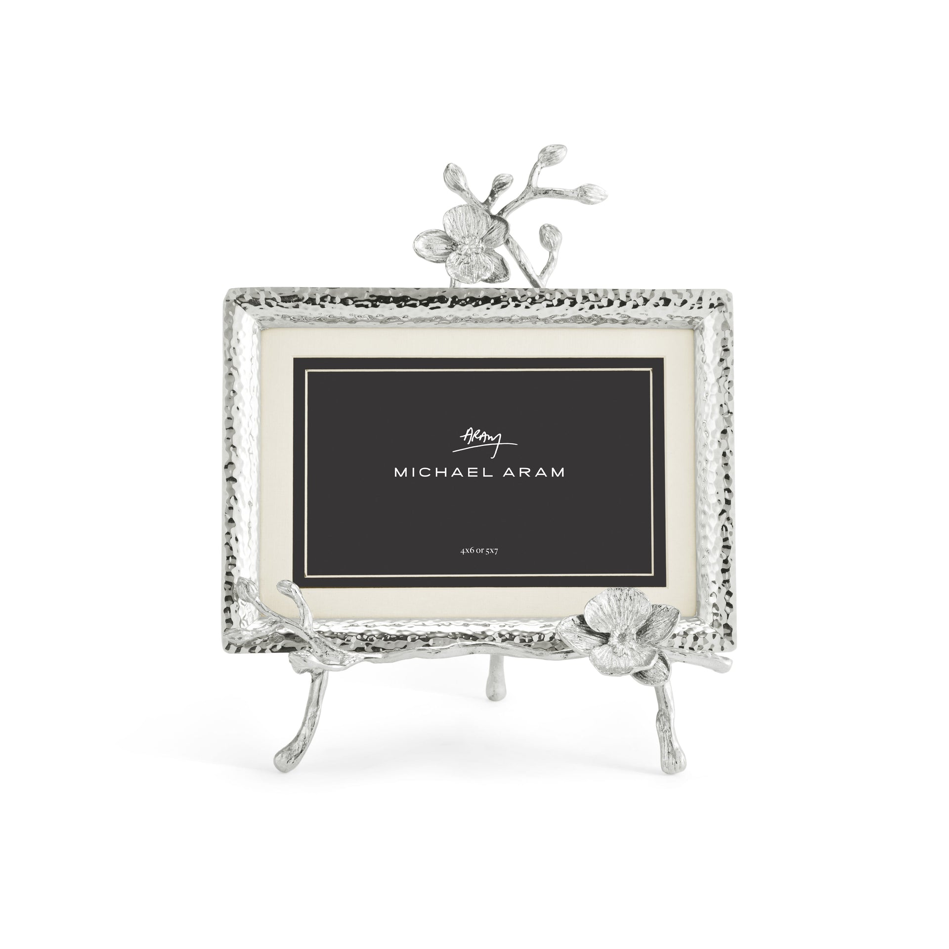 A Michael Aram White Orchid Frame Collection picture frame with textured edges and floral accents displays a card labeled "Michael Aram," evoking the purity and grace of orchids against a white background.