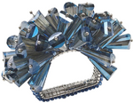 The Kim Seybert Dazzle Napkin Ring features a cluster of angular, translucent blue crystals and faceted glass beads in a spiky, decorative silver design.