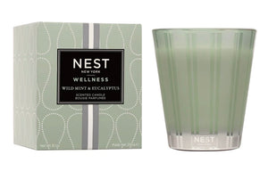 The Nest Wild Mint & Eucalyptus Candle Collection features green glass candles in minimalist packaging, offering a refreshing fragrance blend of wild mint and eucalyptus.