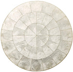 The round table top features a geometric segmented pattern with a silver metallic finish and textured surface—an elegant backdrop for your table or to pair with the Kim Seybert Capiz Placemat.
