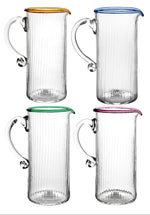 These four clear glass pitchers from the Juliska Nell Collection feature ribbed textures and vibrant rims in orange, blue, green, and purple. Made by Juliska with mouth-blown glass, they're perfect for adding elegance to cocktail-hour gatherings.