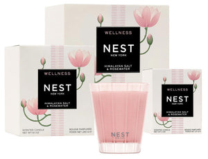Three boxes from the Nest Himalayan Salt & Rosewater Candle Collection and a pink glass candle are displayed against a white background, highlighting the soothing rosewater and amber notes.