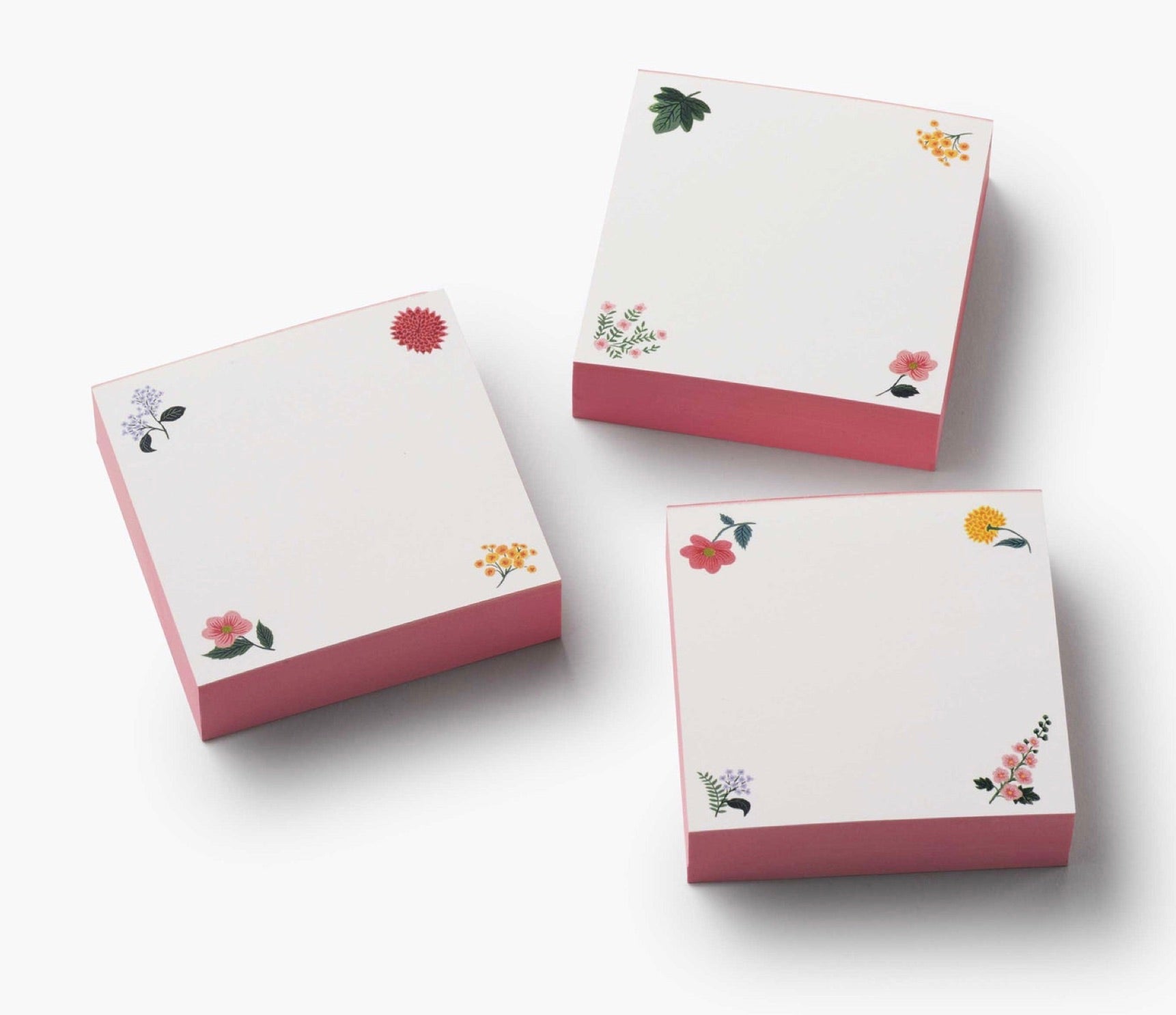 Three square sticky note pads from the Dahlia Collection by Riffle Paper Co., featuring pink sides and floral corner accents, arranged on a white background—a charming addition to your stationery.