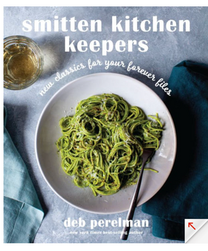 The cover of "Smitten Kitchen Keepers" by Penguin Random House shows green pesto pasta beside a glass of white wine and a blue napkin—an ideal pick for fans of inspiring cookbooks.