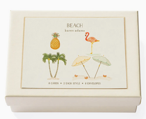 The Beach Card Set by Karen Adams comes in a cream box with hand-embellished note cards featuring pineapples, flamingos, palm trees, and beach umbrellas—a perfect gift for any occasion.