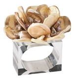 The Tahiti Natural Napkin Ring by Kim Seybert features overlapping, polished shell pieces arranged on a rectangular clear acrylic base with an open center, adding tropical style to any table setting.