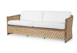 The PALECEK Capitola Outdoor Sofa in Nit Witty Sea Salt features a woven tan synthetic seagrass frame and white cushions, shown on a plain white background—an ideal outdoor furniture addition for any patio or garden.