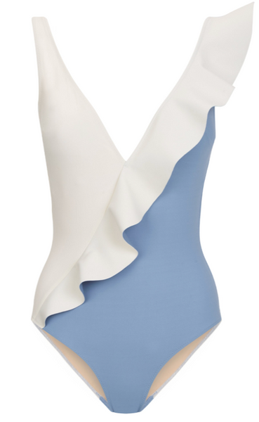 A luxurious Evarae Otto One Piece swimsuit with an asymmetrical design featuring a white overlay on a blue base.