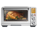 A whole roasted chicken with vegetables is inside the Breville Smart Oven Air Fryer Pro, visible through the glass door with the controls and temperature display on the right.