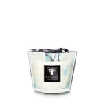 A Baobab Pearls Sapphire candle in a hand-blown glass container with a swirling white and turquoise design.