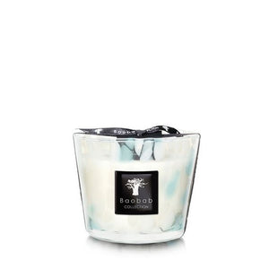 A Baobab Pearls Sapphire candle in a hand-blown glass container with a swirling white and turquoise design.