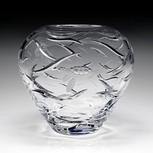 The William Yeoward Crystal Persephone Centerpiece Vase features clear glass with copper-wheel engraved fish and wave patterns, showcased on a plain gradient background.