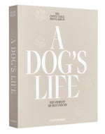 The PrintWorks "A Dog's Life Photo Album" is shown standing upright with a beige hardcover and acid-free pages to help preserve your memories for years to come.