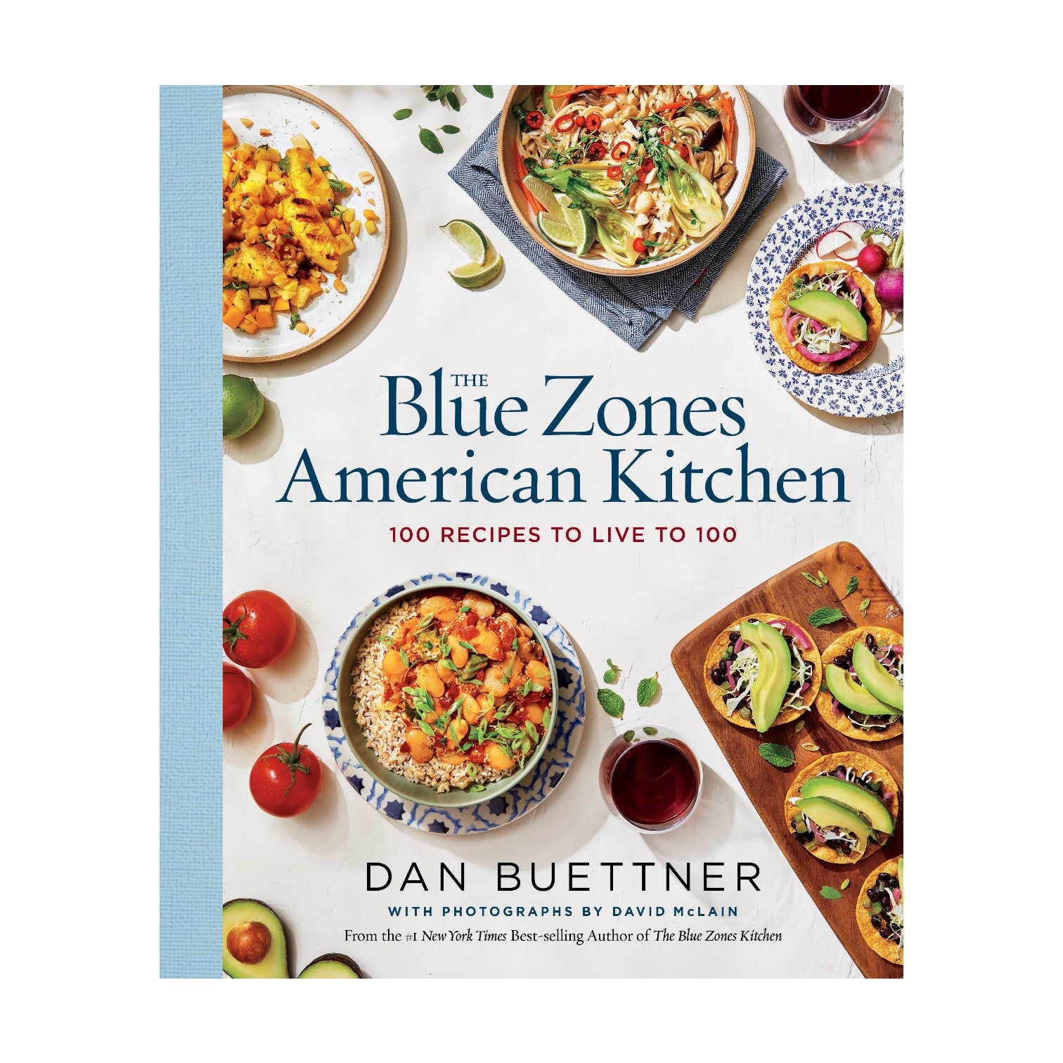 The cover of “Blue Zones American Kitchen,” published by Penguin Random House, displays vibrant plant-based dishes with the subtitle “100 Longevity Recipes to Live to 100” and features author Dan Buettner, highlighting this vegetarian cookbook.