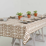 A dining table with a Pomegranate Inc. Brown Bamboo Collection by Pomegranate Inc. is set with glassware, napkins, and cutlery. Small potted plants are placed along the center.