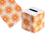 The Radiant Bath Collection by Haute Home includes a cube-shaped tissue box cover in luxurious Italian linen, featuring an orange and gold starburst pattern.