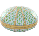 The Herend Sea Urchin Box in Key Lime Green features a round porcelain design with a hinged lid, adorned with green leaf patterns, gold dots, and a gold rim. Expertly hand painted to highlight the elegance and durability of fine craftsmanship.