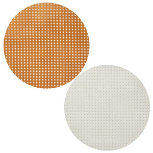 The Kim Seybert Reed Placemats, one brown and one white, feature a round, textured grid design reminiscent of faux-wicker—ideal for outdoor entertaining—shown on a simple white background.