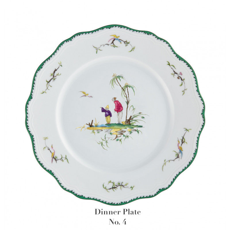 White dinner plate from the Longjiang Dinnerware Collection by Raynaud features scalloped green edge, floral details, and a central scene of two figures under a tree. Text below reads "Dinner Plate No. 4." Perfect for timeless faience-style dinner services.