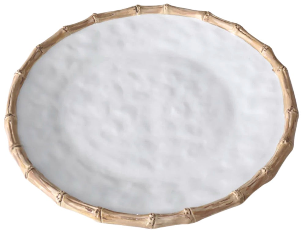 A round white plate from the Beatriz Ball Vida Natural Bamboo Serveware Collection features a textured surface and bamboo-inspired rim, blending break-resistant durability with elegant, luxury melamine design.
