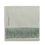 Alicia Adams Alpaca’s Classic Herringbone Throw Collection features a folded light green baby alpaca blanket with fringed edges and a fabric label, fair-trade made in Peru for luxurious softness.