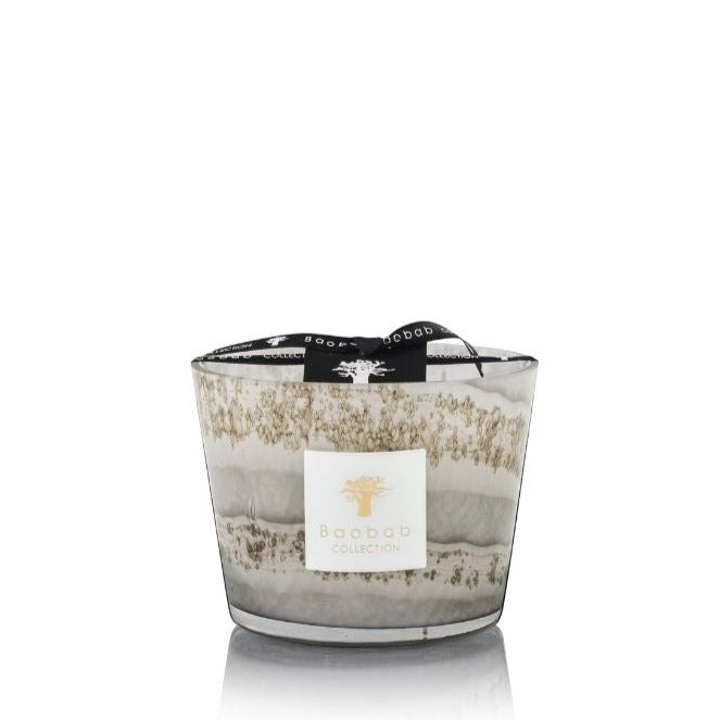 A Baobab Sand Atacama Candle in a grey and white marbled glass container with an Earl Grey Tea scent, adorned with a black ribbon and brand label.